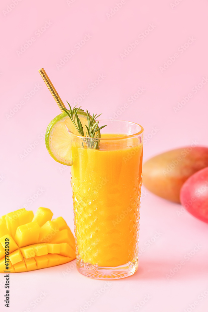 Glass of tasty mango smoothie on color background