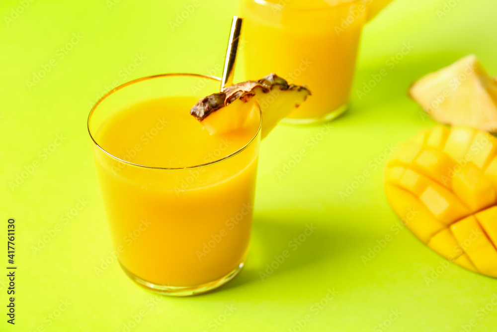 Glass of tasty mango smoothie on color background