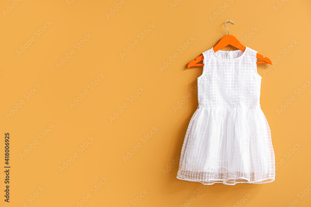 Hanger with dress on color background