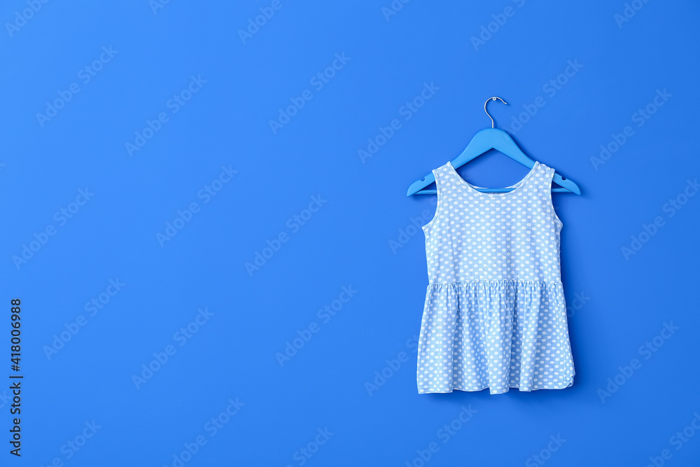 Hanger with dress on color background