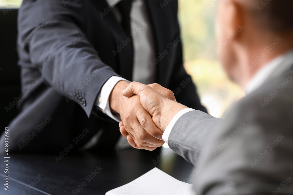 Businessmen shaking hands in office