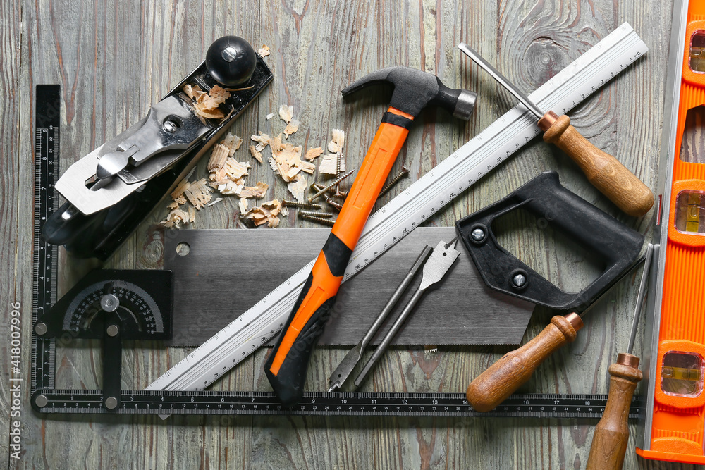 Set of carpenters tools and saw dust on wooden background