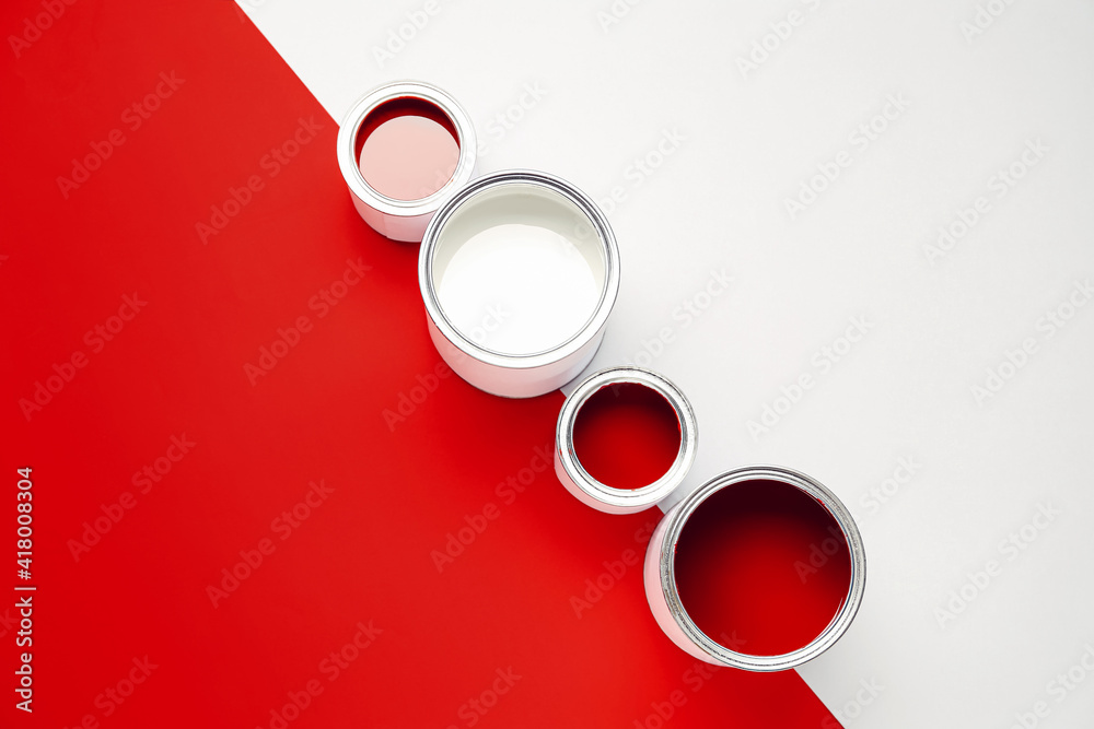 Cans of paints on color background