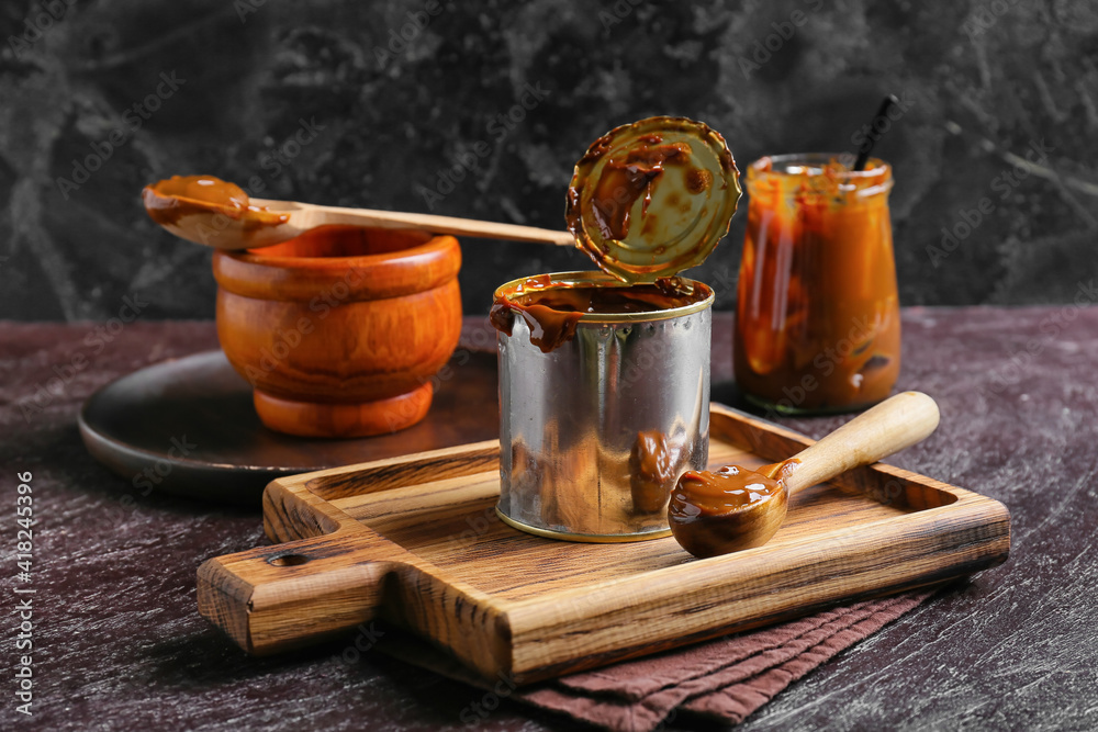 Tin can of boiled condensed milk on dark background