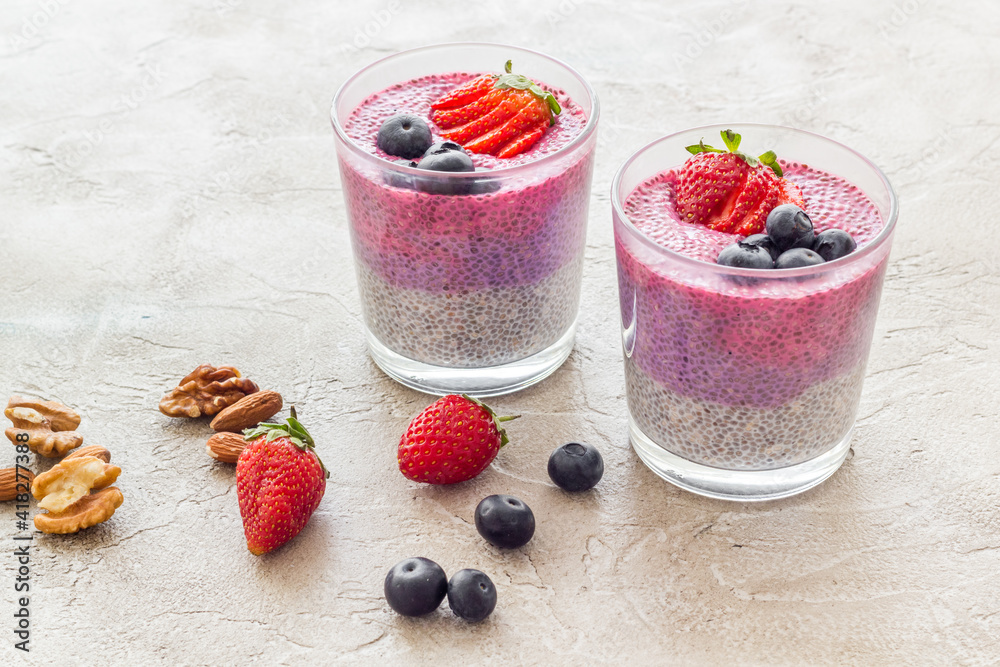 Chia pudding smoothie dessert wirh strawberries in glass jars. Vegan healthy breakfast.