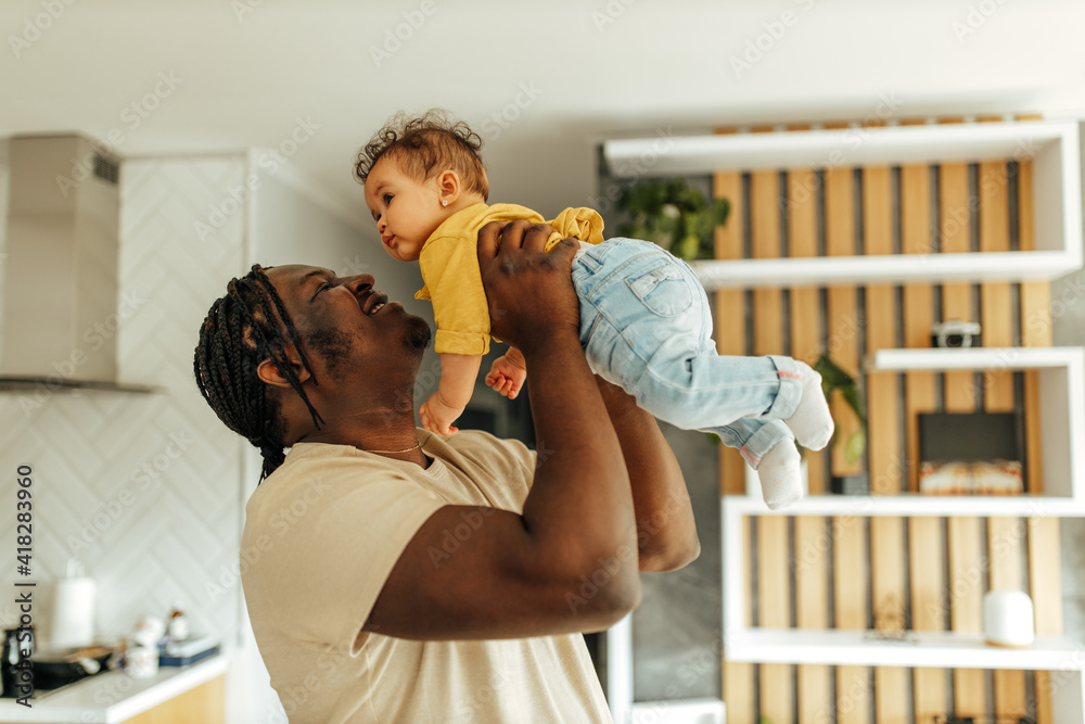 Dad holding his baby girl, smiling face.