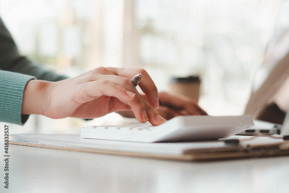 businessman or accountant hand working on calculator to calculate business data, accounting document