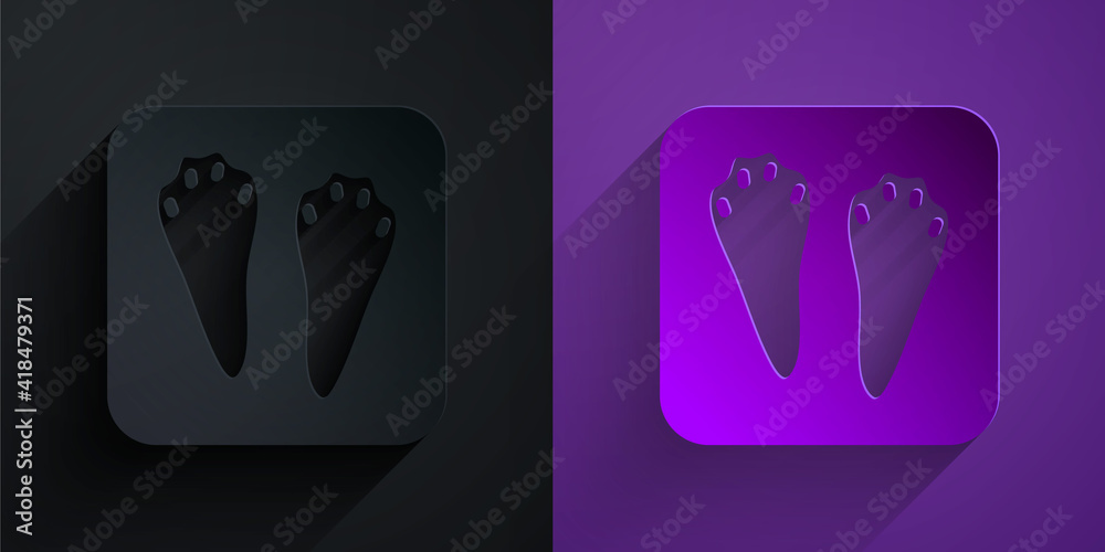 Paper cut Rabbit and hare paw footprint icon isolated on black on purple background. Paper art style