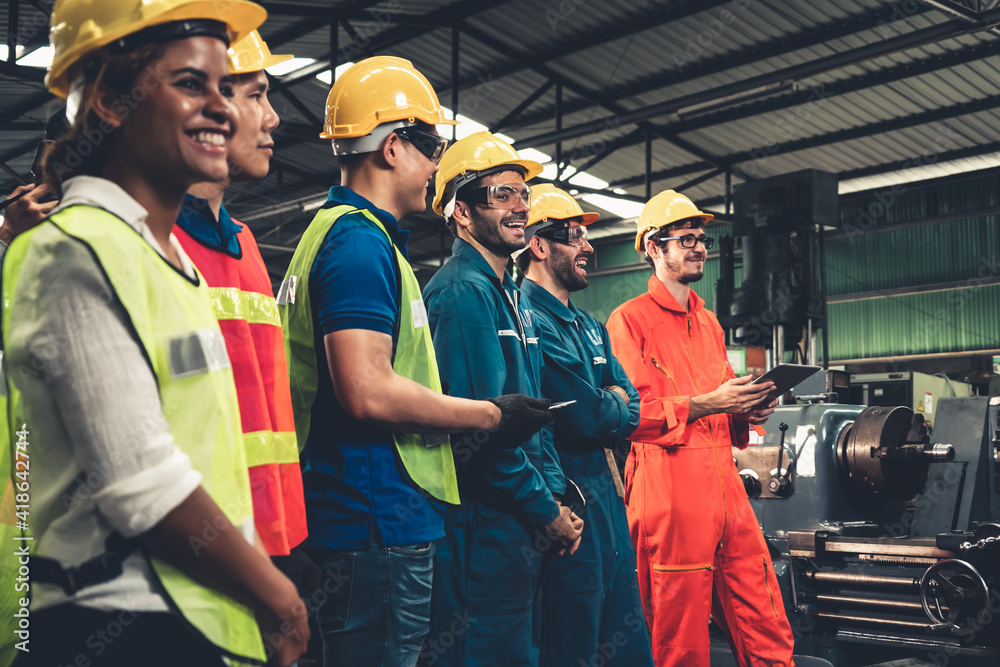 Skillful worker attending brief meeting in the factory . Industrial people and manufacturing labor c