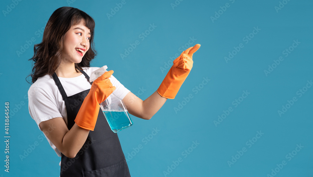 A photo of an Asian woman in an apron and gloves preparing for the cleaning job