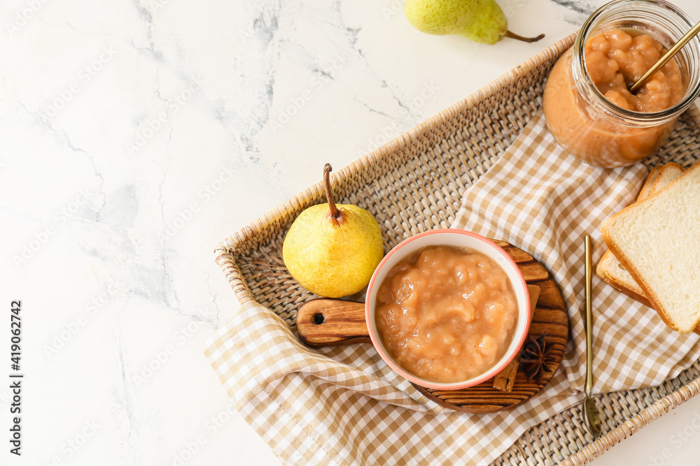 Tray with tasty pear jam and bread on white background