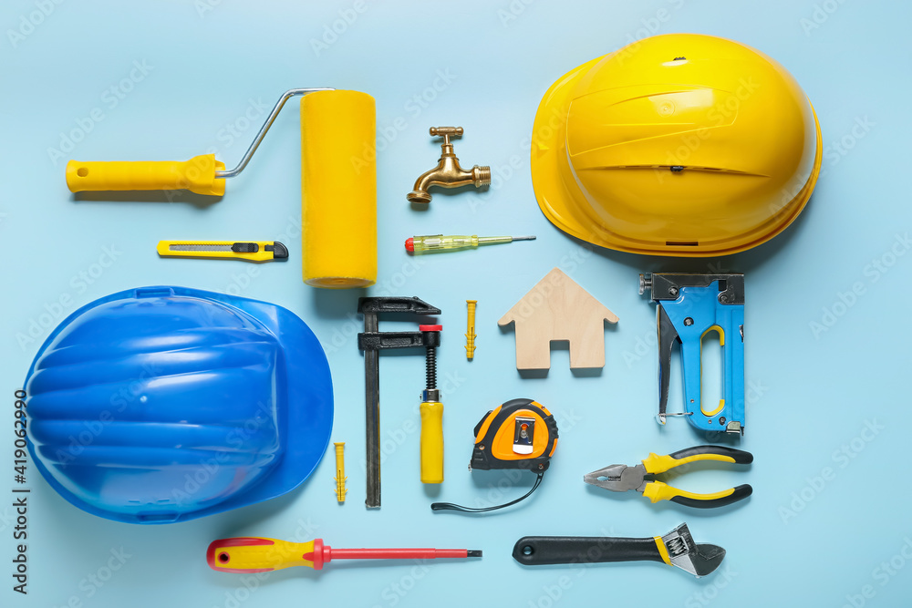 Composition with figure of house and construction tools on color background