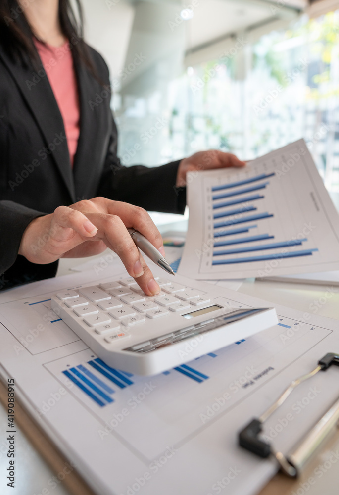 businessman working on desk office with using a calculator to calculate the numbers, finance account