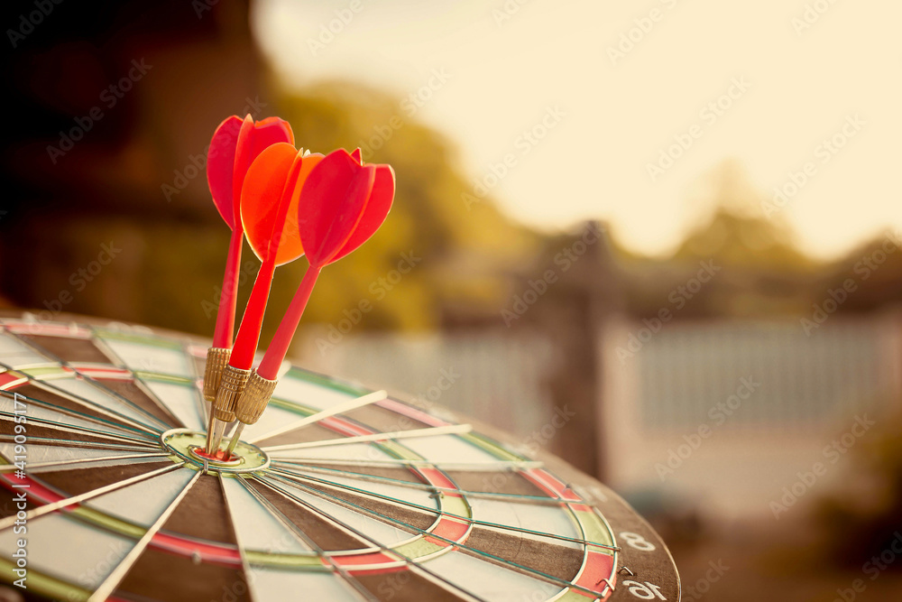 Close up shot of the dart arrow hit on bulleyes of dartboard to represent that the business reached 