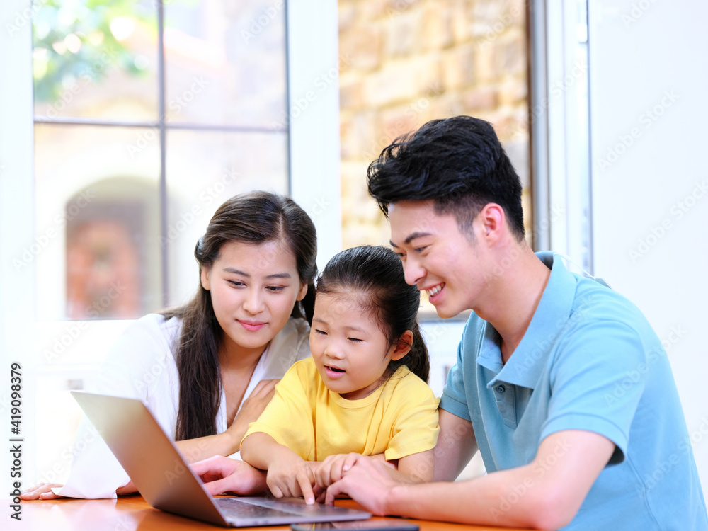 Happy family of three using laptop