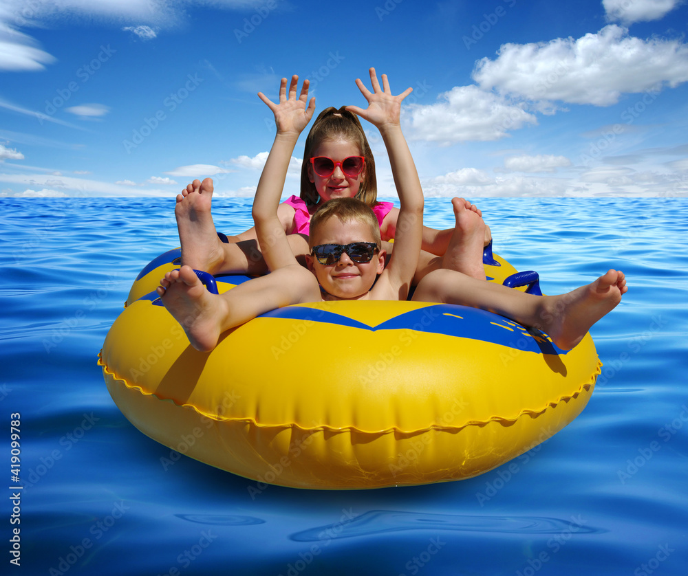 Boy and girl on inflatable float in blue sea water.