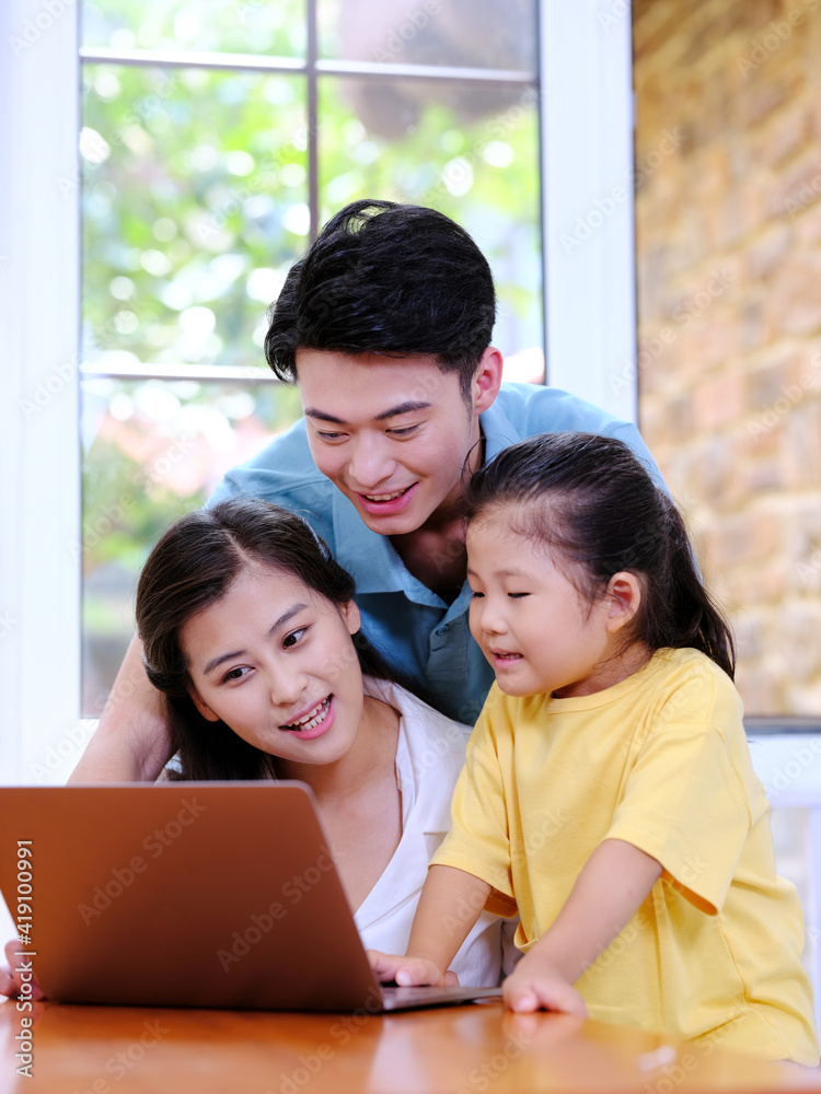 Happy family of three using laptop