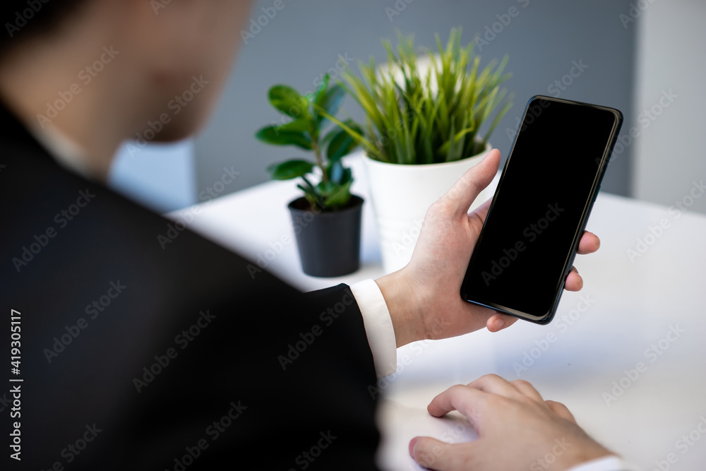 Asian business man dringking coffee wearing suit, enjoying watching educational webinar on laptop or