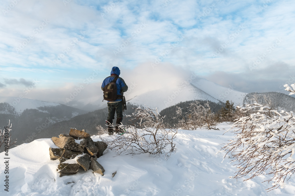 Alone photographer in snowy hills in hight winter mountains in sunrise time. Travel concept. Carpath