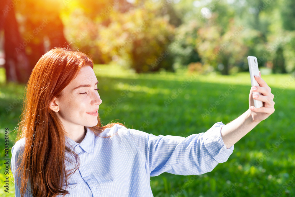 Young redhead woman taking selfie photo