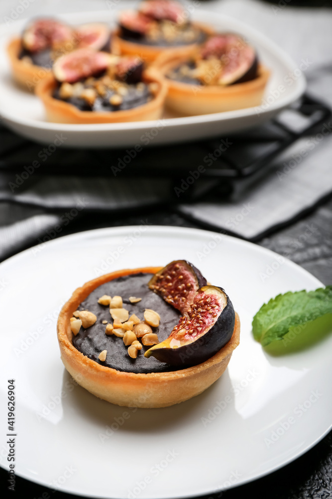 Tartlet with tasty chocolate paste and figs on dark background