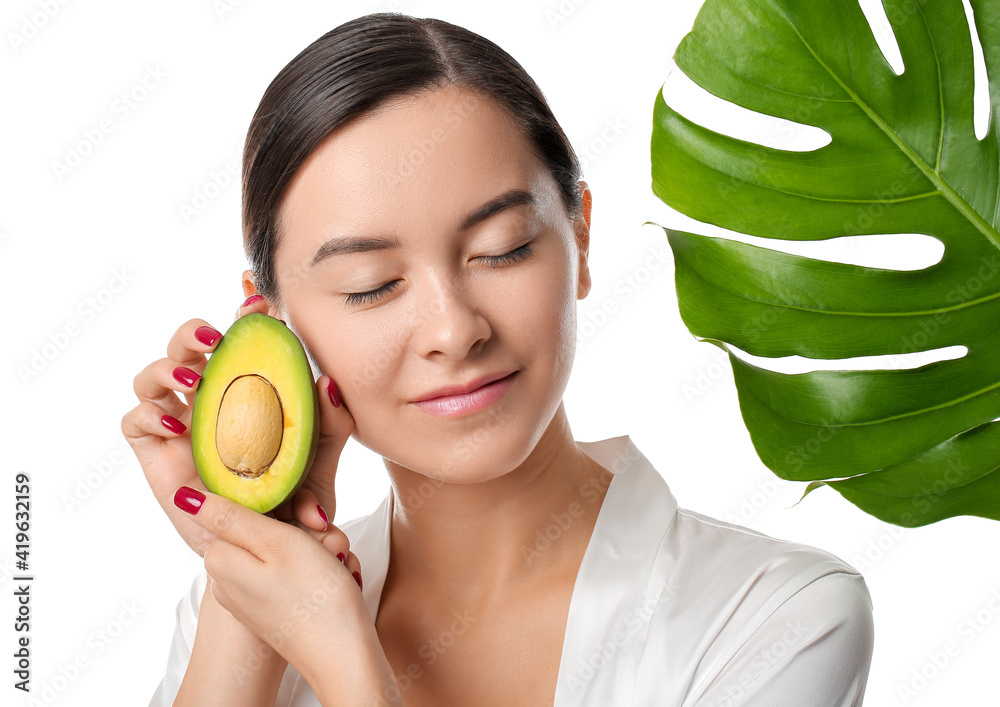 Beautiful young woman with avocado on white background