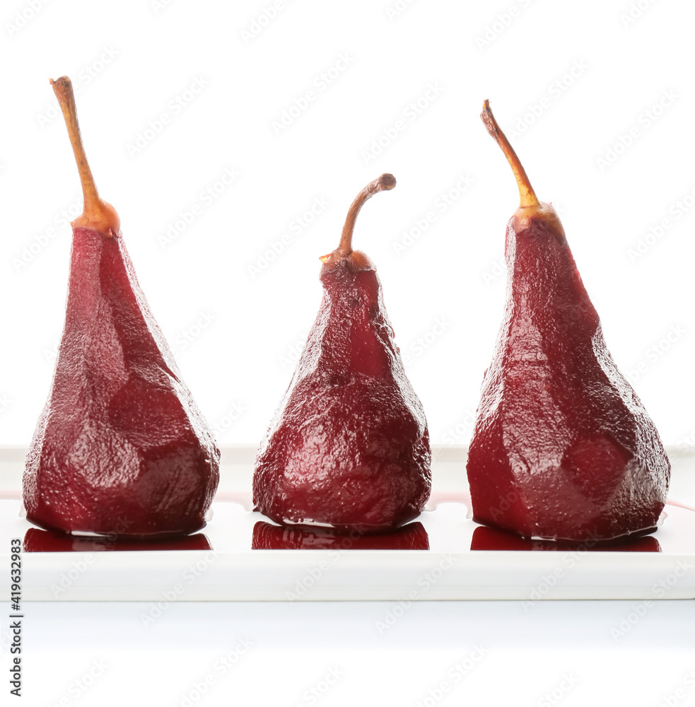 Plate of tasty poached pears in wine sauce on white background