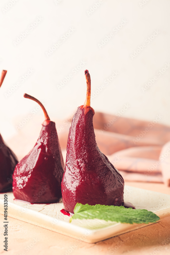 Plate of tasty poached pears in wine sauce on light background