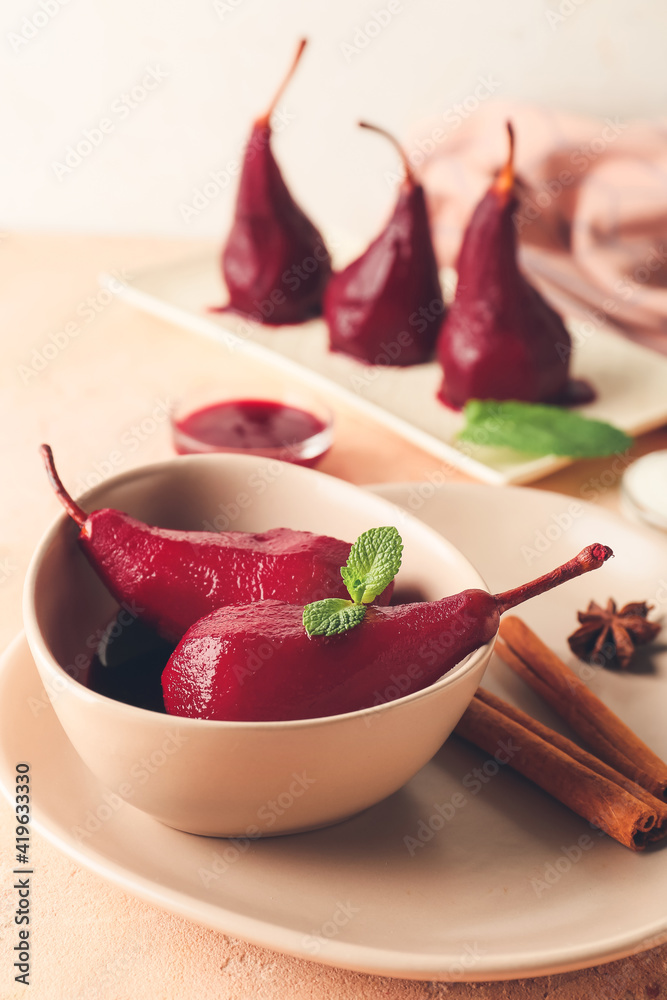 Bowl of tasty poached pears in wine sauce on table