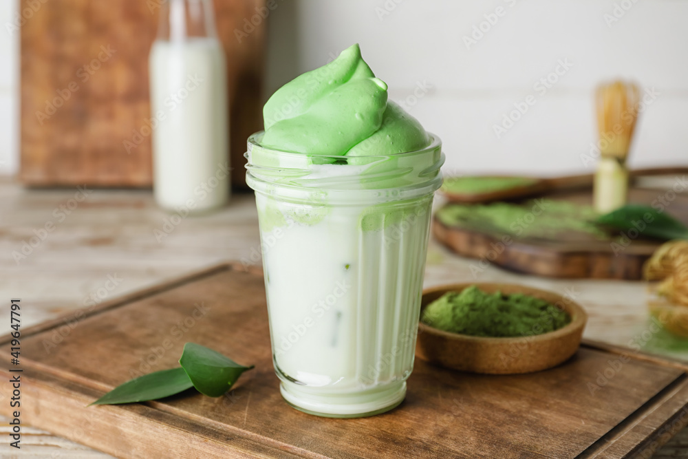 Composition with tasty dalgona matcha latte on wooden background, closeup