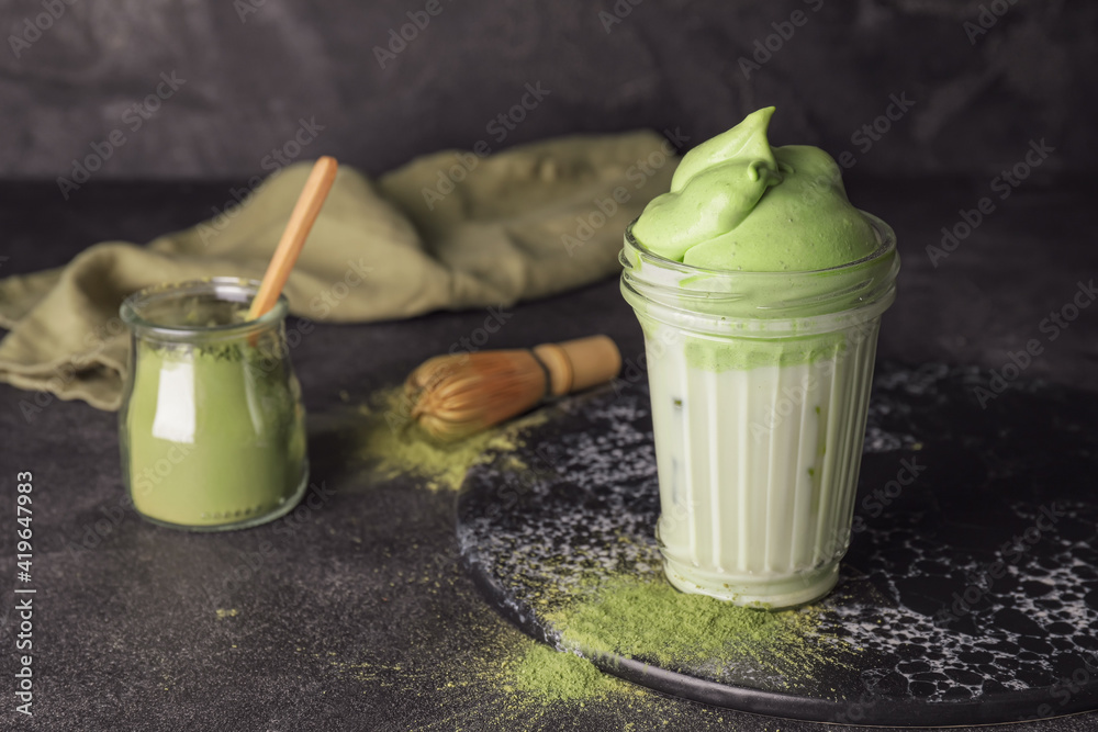 Composition with tasty dalgona matcha latte on dark background