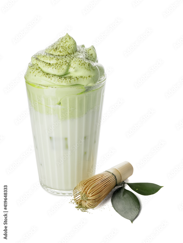 Glass of tasty dalgona matcha latte and chasen on white background