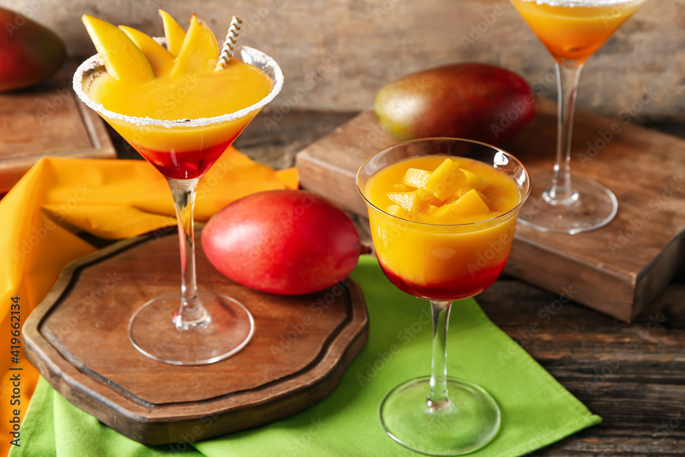 Glasses of mango margarita on wooden background