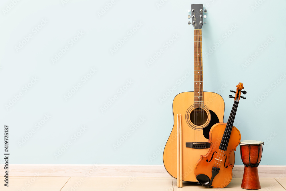 Different musical instruments near color wall