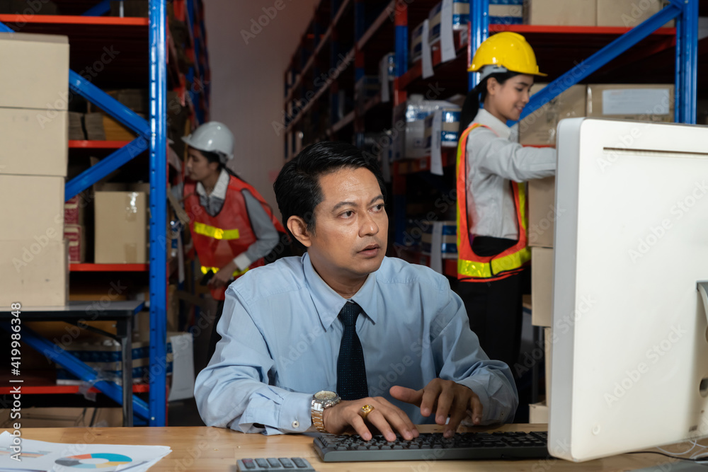 Warehouse manager and worker working in the storehouse . Logistics , supply chain and warehouse busi