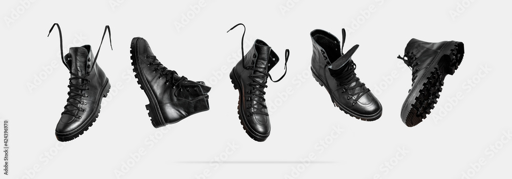 Black flying leather men's or women's boots isolated on light gray background. Fashionable