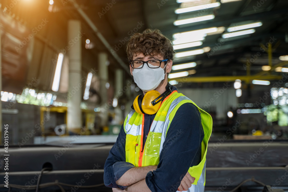 Engineer wearing protection face mask are working on projects in large industrial plants.