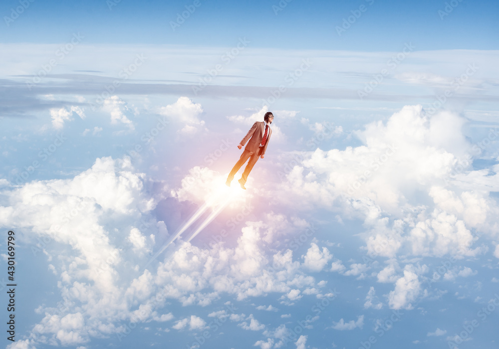 Businessman in suit and aviator hat flying in sky