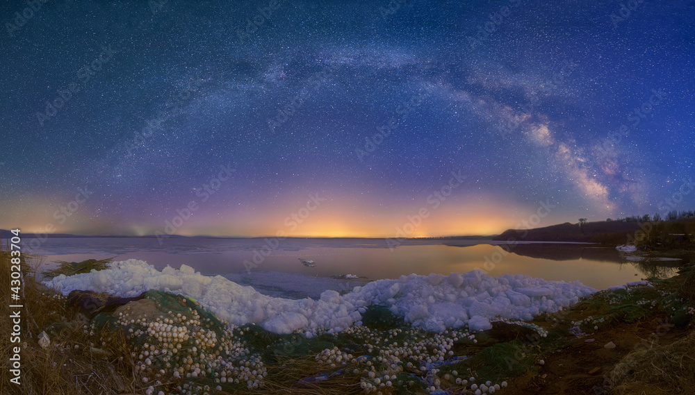 The milky way and star trails in sky, ice and snow.