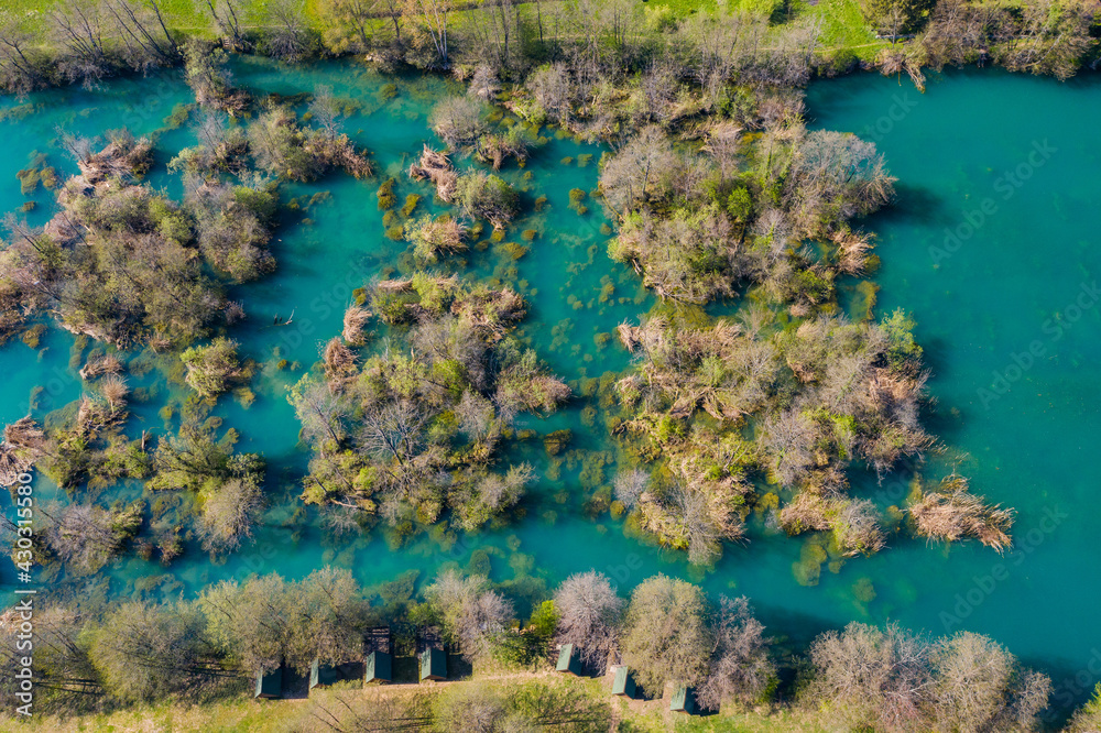 Croatia, Mreznica river from drone, overhead shot of waterfalls and trees in spring. Small wooden te