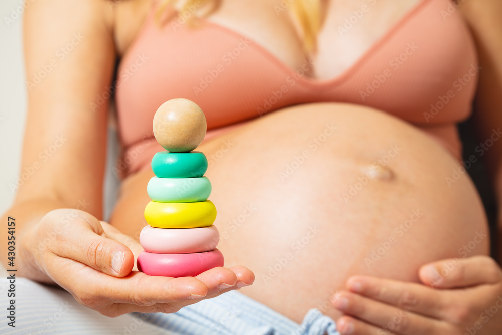 Pyramid toy in pregnant womans hands near belly