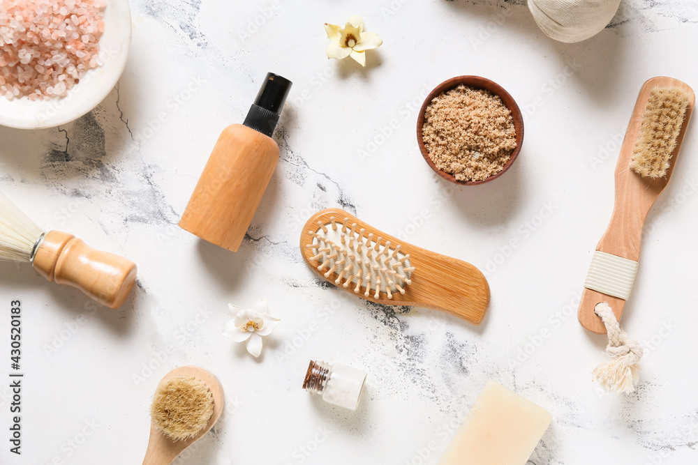 Composition with massage brushes and bath supplies on light background