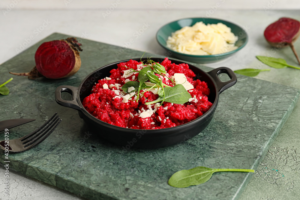 Frying pan with tasty beet risotto on table