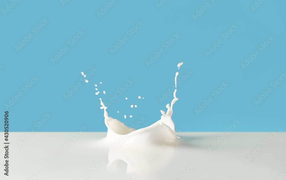 Splashes of tasty milk on color background