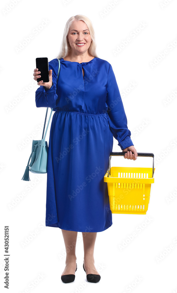 Mature woman with shopping basket and mobile phone on white background