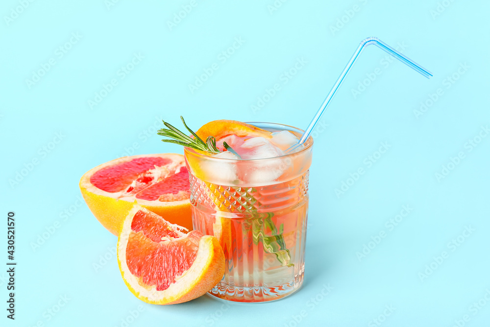 Glass of tasty grapefruit lemonade on color background