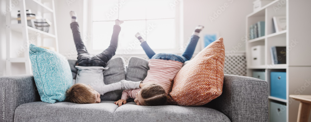 Cute children lying face down on the sofa