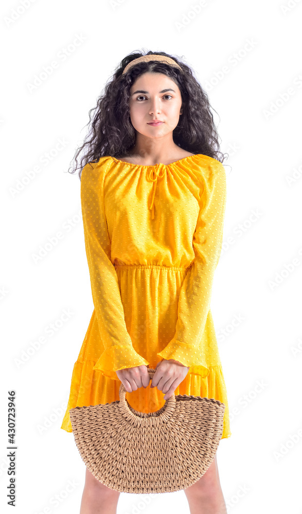 Portrait of fashionable young woman with wicker bag on white background