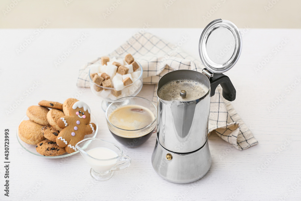 Coffee maker, cookies and cup of espresso on table in kitchen