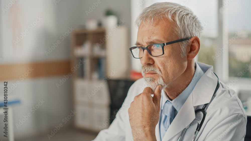 Experienced Middle Aged Male Doctor Wearing White Coat Working on Personal Computer at His Office. S